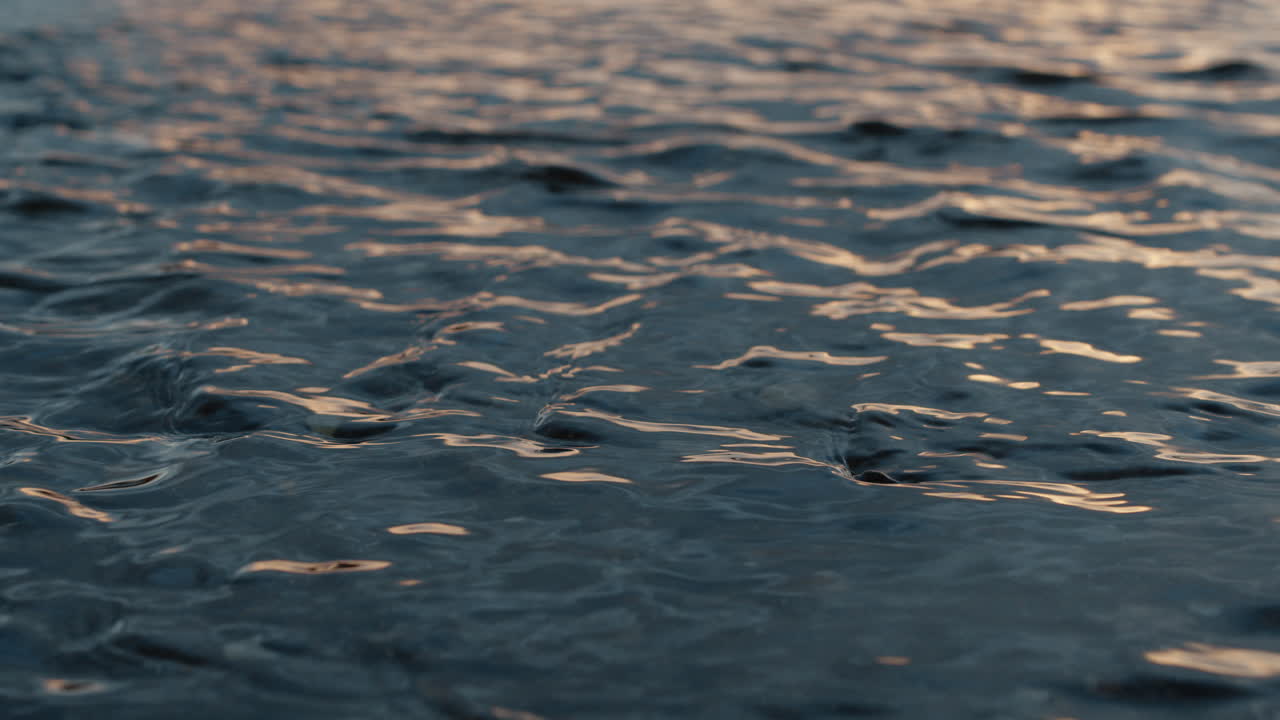 Shallow water flowing in ripples at sunset, closeup