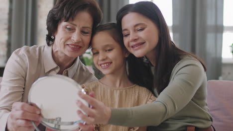 three generations of women looking in a mirror