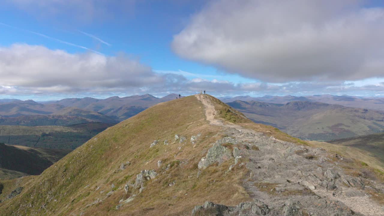 wide angle shot of multiple hikers at the Ben Vorlich summit during summer