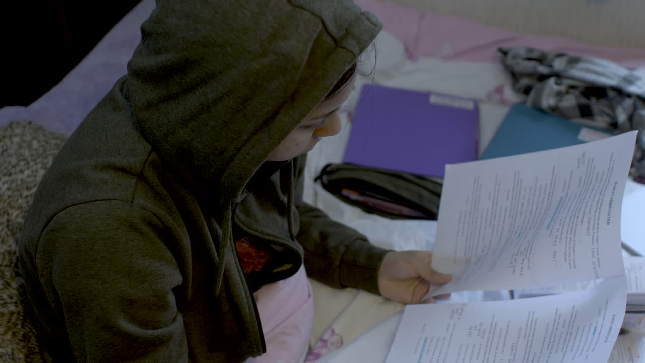 Young Woman Studying on Her Bed