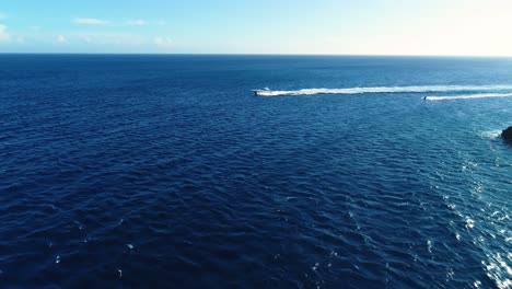 jet ski y yate barco de velocidad conducir rápidamente a través del océano abierto aguas del caribe, visión aérea