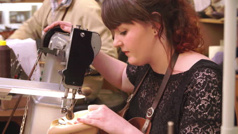 bespoke shoemaker stitching together leather pieces for shoe