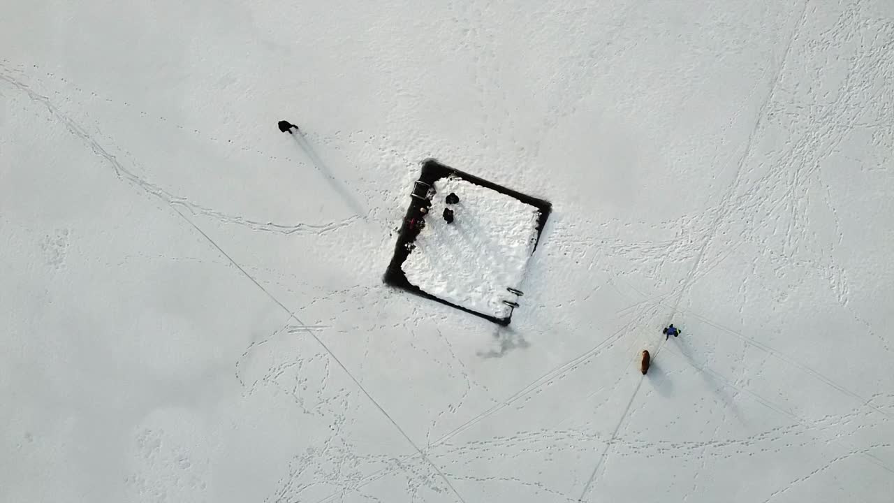 사람들과 애완견이 캐나다의 휘슬러에 있는 수영장과 함께 얼어붙은 호수에서 겨울을 즐기고 있습니다.