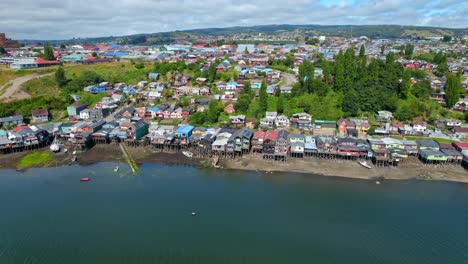 Luftdrohne-Fliegt-über-Die-Küste-Des-Chilenischen-Inseldorfs-Chiloé,-Häuser-Am-Himmel-Und-Strandufer,-Skyline-Bei-Tageslicht-In-Südamerikanischem-Reiseziel