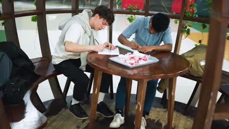 aerial view of two colleagues standing side by side on concrete floor wearing black and white sneakers paired with long tube socks showcasing contemporary streetwear focus on footwear and casual style