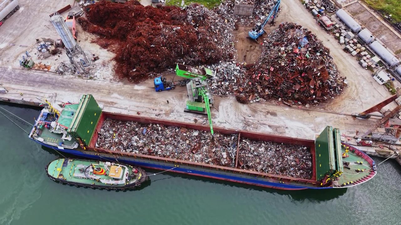 Nave da carico che carica rottami metallici in un molo in un'area industriale