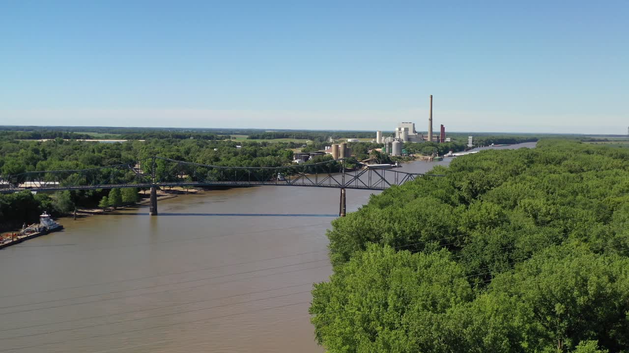 Bilbro, frodig skov og industriel baggrund, fremadgående luftfoto.