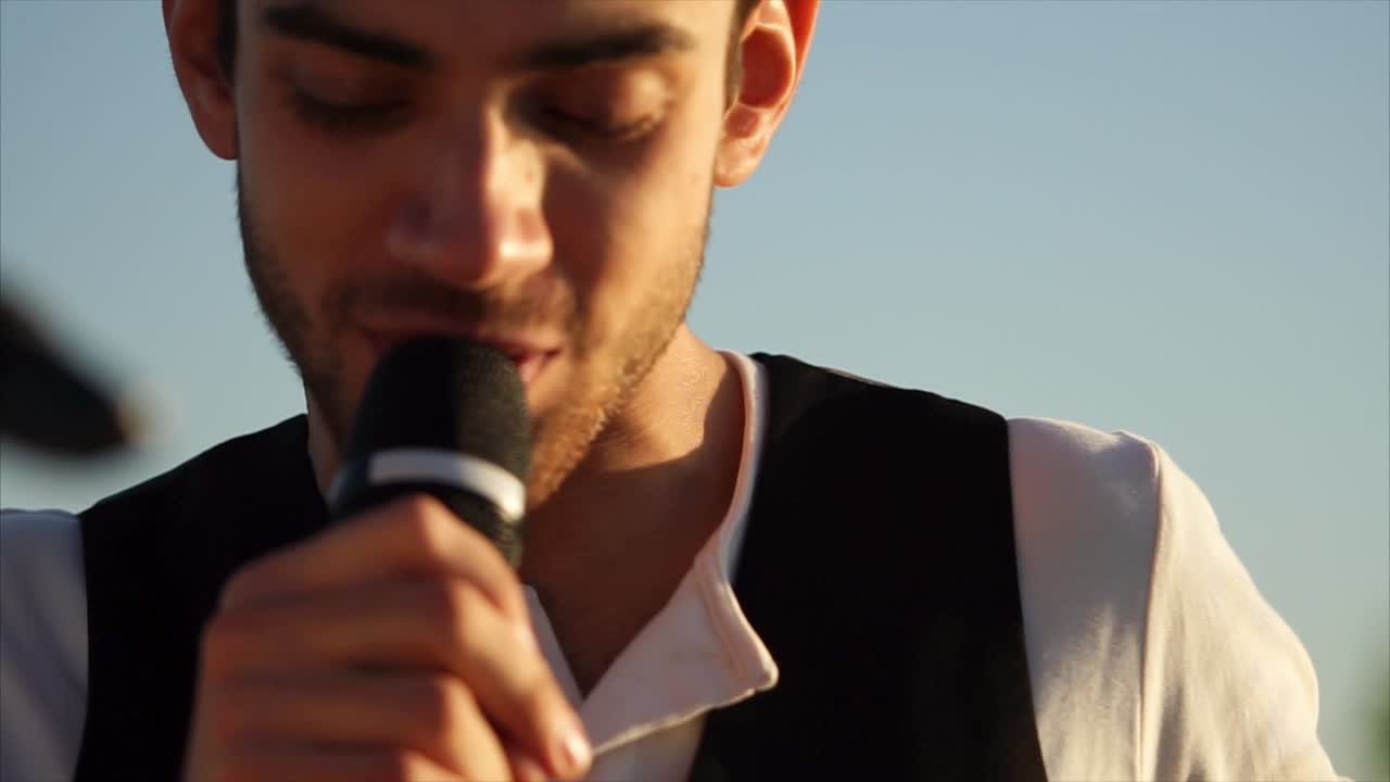 Uomo che canta con microfono all'aperto