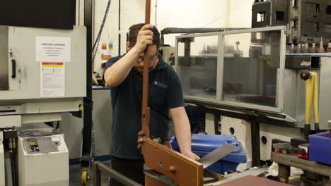 worker cutting sheet metal on a guillotine sheer