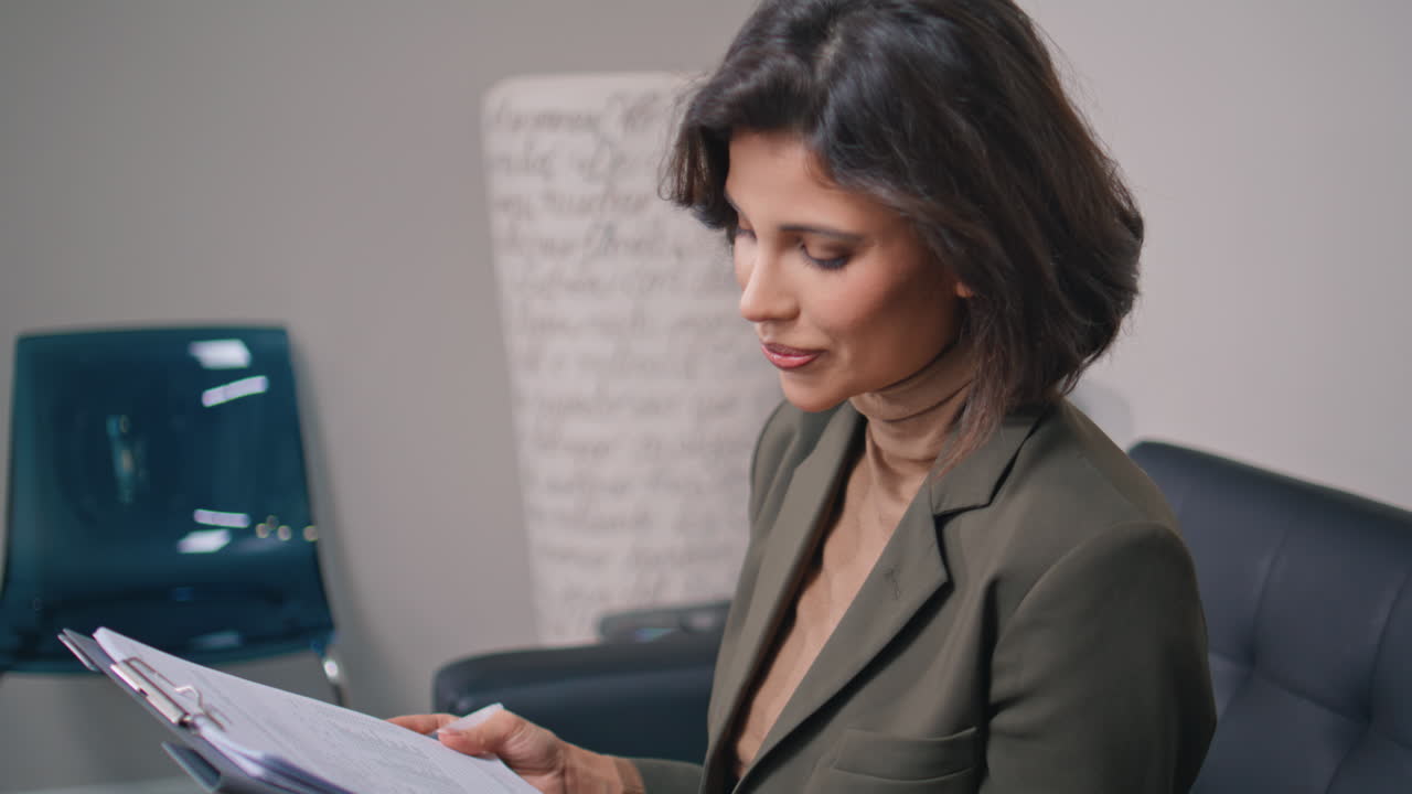 Woman reading medical documents sitting couch healthcare office closeup
