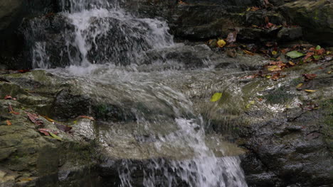 Small-waterfall-cascading-over-rocky-terrain-in-Cajones-de-Chame,-Panama,-surrounded-by-lush-greenery