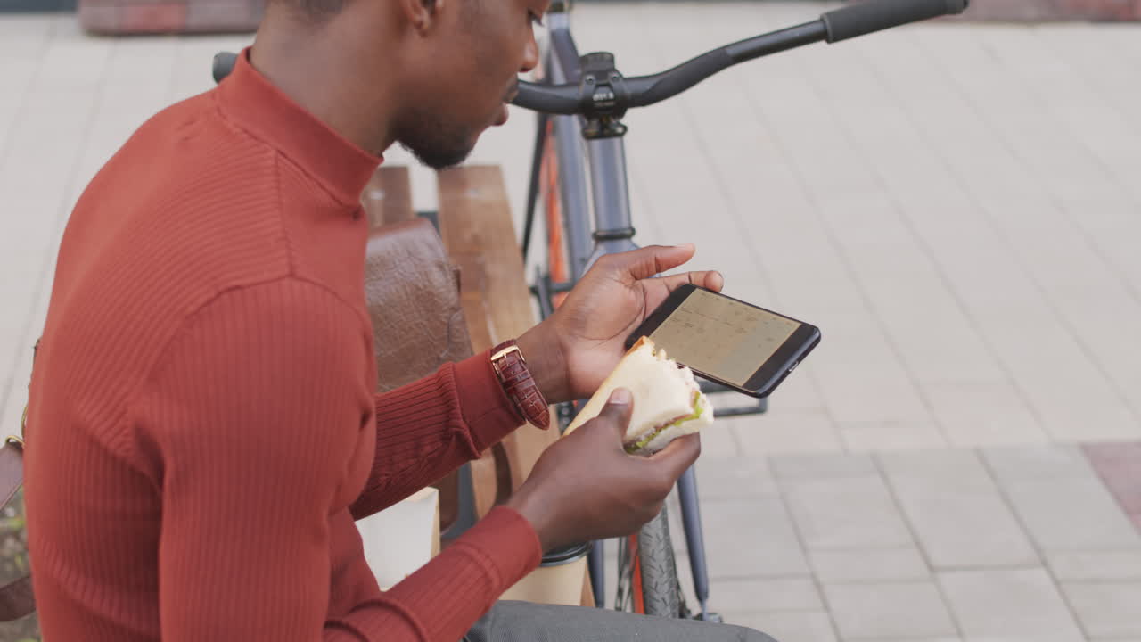 African-American Man Looking at Smartphone during Lunch Break