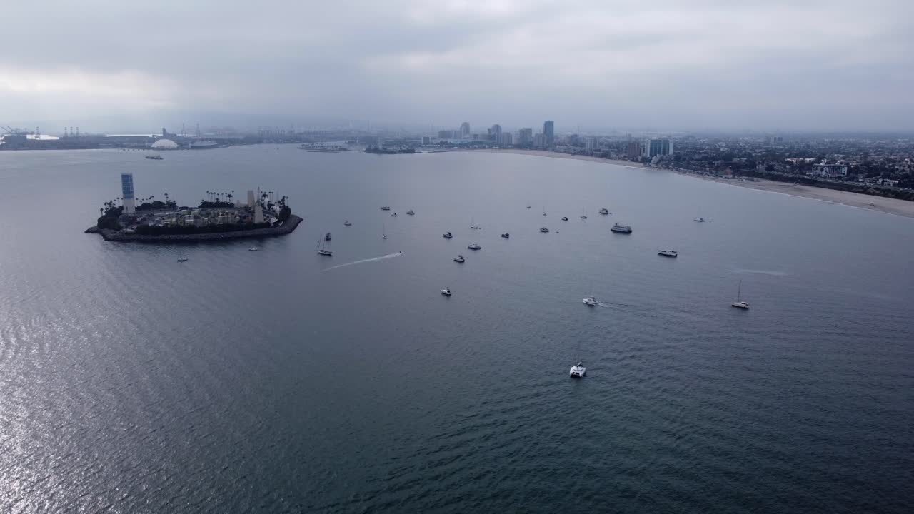아름다운 공중 드론 샷, 드론이 캘리포니아 롱비치의 해변과 스카이라인을 감상하는 썸스 섬 위로 날아갑니다.