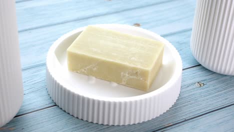 jabón de barra natural en un plato de jabón blanco