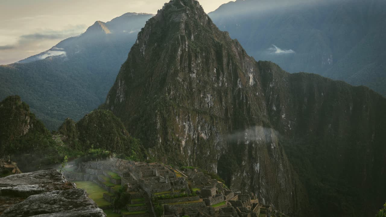 An epic time lapse of Machu Picchu, Peru, transitioning from morning to midday as clouds rise and sunlight breaks through on mountain peaks