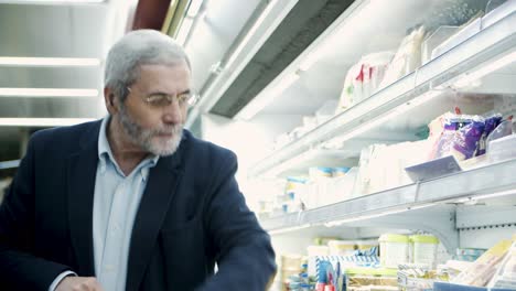 mature man choosing products in store