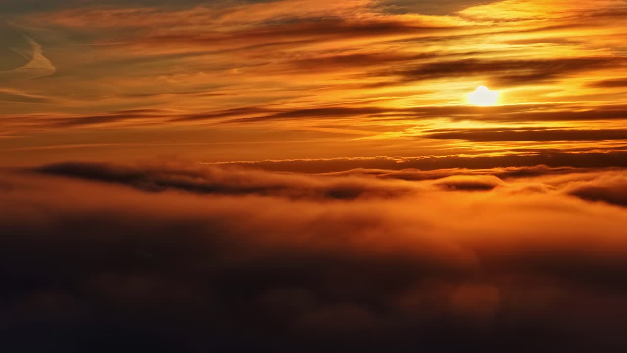 Drohnenflug über Wolken im nebligen Sonnenuntergang der goldenen Stunde, malerische Skyline-Landschaft in Zeitlupe.