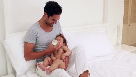 padre guapo alimentando a su bebé