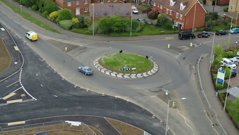 static aerial view of a uk police van crossing a roundabout