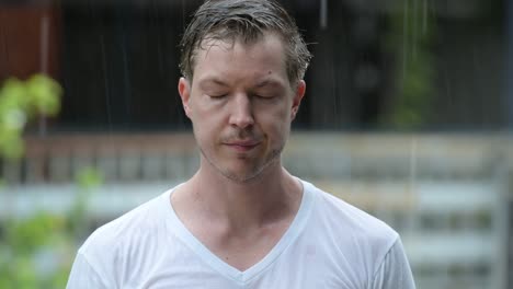 face of sad young man alone in the rain outdoors