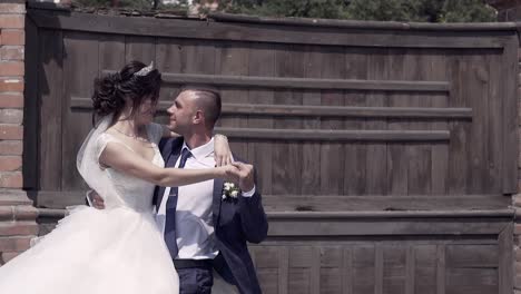 slow-motion-man-raises-bride-in-wedding-dress-with-veil