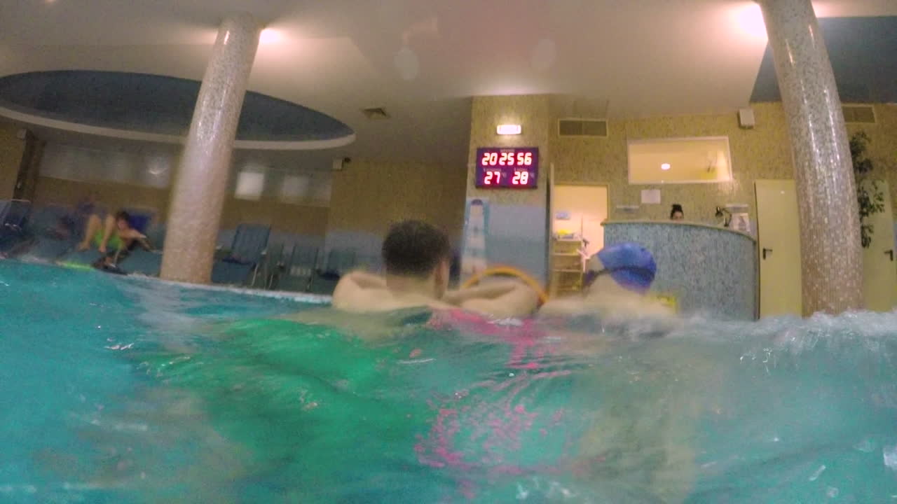 padre e hijo bañándose en la piscina cubierta