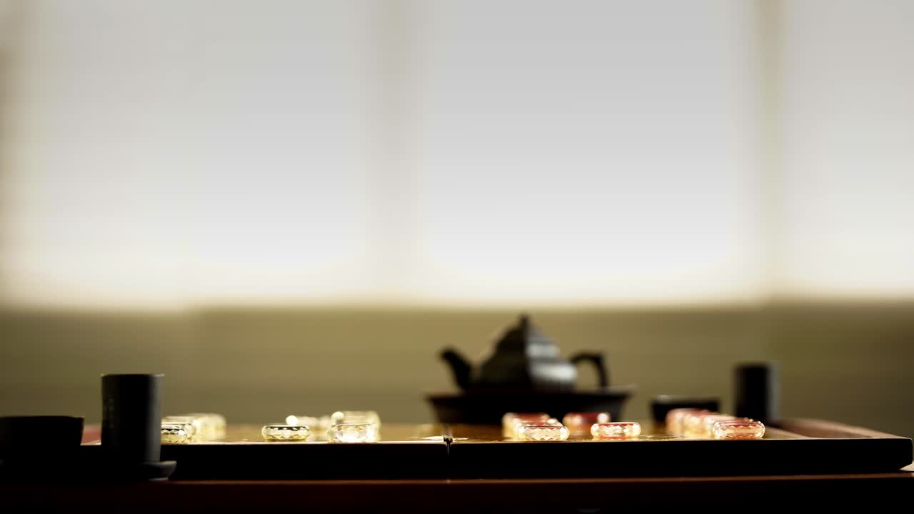 juego de té chino y vidrio ajedrez chino en el tablero de ajedrez dorado