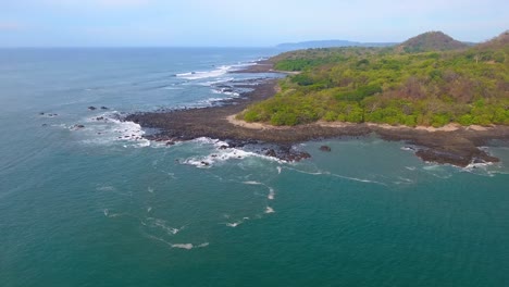 drone shot flying away from piedra point on the nicoya peninsula in costa rica on a sunny summer day