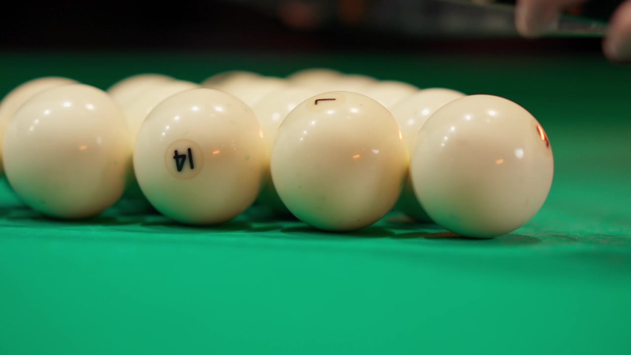 Mani che sistemano le palle da biliardo su un tavolo verde
