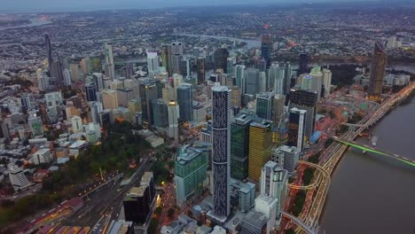 Hyperlapse-Zeitraffer-Aus-Der-Luft-Des-Stadtzentrums,-Hoher-Gebäude,-Eines-Flusses-Und-Schnell-Fließenden-Verkehrs-Am-Abend