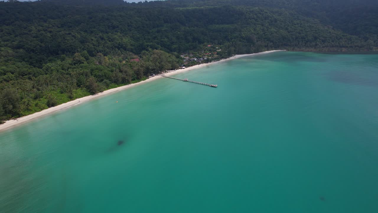 Tayland, Trat'taki Ao Phrao Plajı'nda uzun ahşap iskeleye sahip geniş turkuaz koyun havadan geri çekilmeli, yukarı eğimli çekimi.