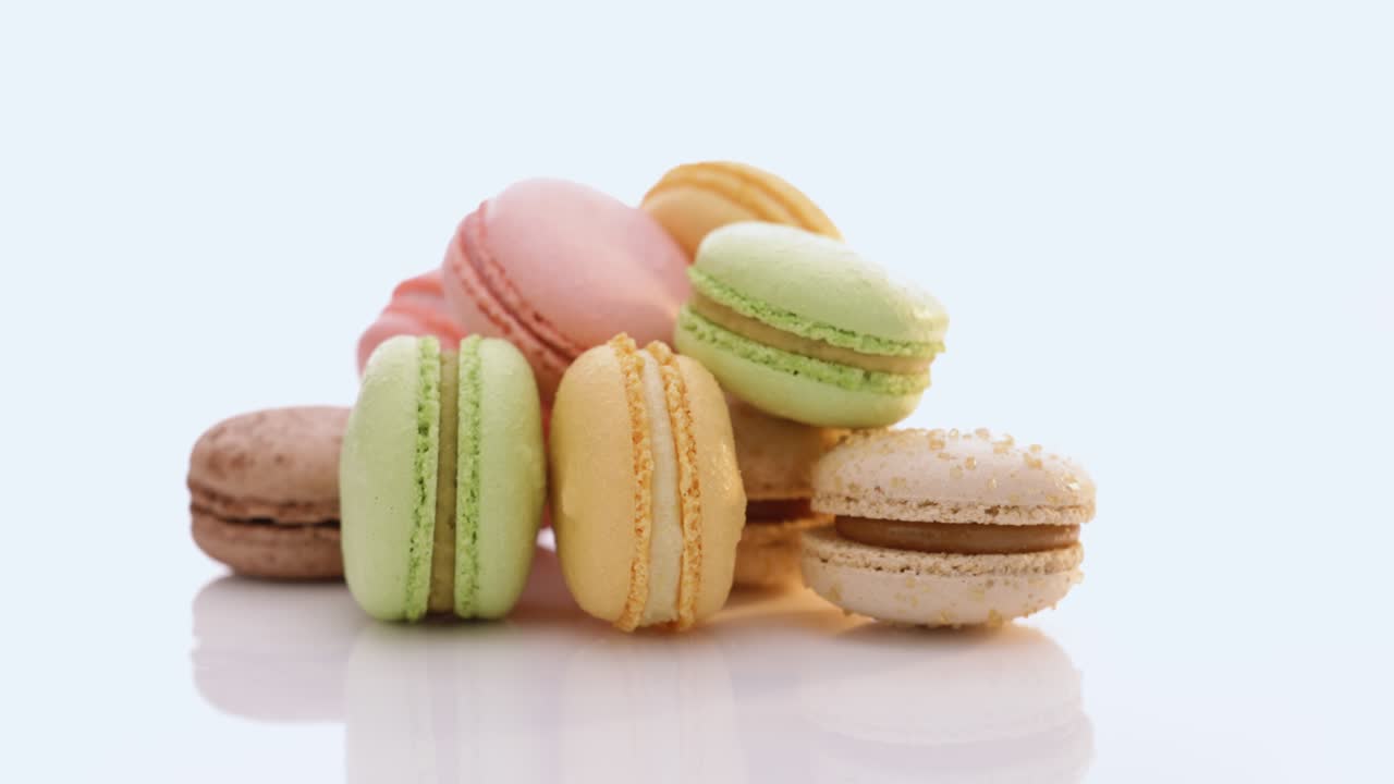 macarones multicolores cookies rotación. macarons multicolores, macarones franceses, pasteles codiciosos. concepto de comida en uhd 4k imágenes