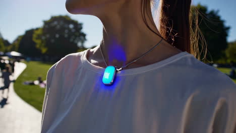 woman wearing a smart necklace in a park