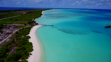 Abandoned-tropical-island-with-old-ship-anchored-in-beautiful-blue-bay-4k