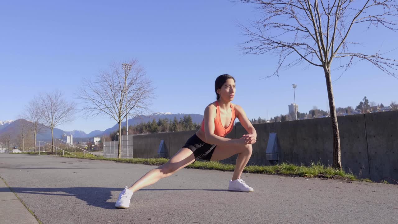 mujer joven sentada en una pose de estocada lateral de yoga y repitiendo en el lado opuesto