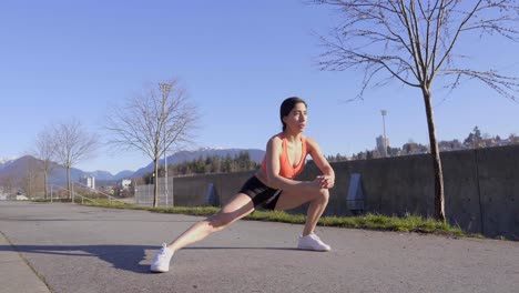 young woman sitting into yoga side lunge pose and repeating on opposite side