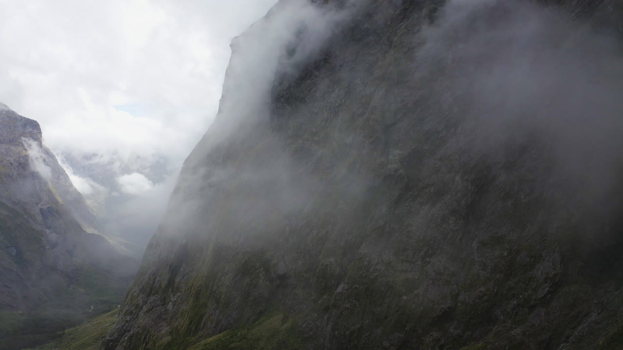 camino sinuoso que pasa a través de las montañas, la niebla y las nubes en milford sound nueva zelanda en la isla sur