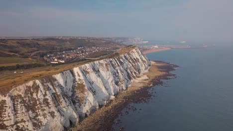 Drohne-Fliegt-Entlang-Der-Sonnigen-Weißen-Klippen-Von-Dover-Mit-Wunderschöner-Landschaft-Im-Hintergrund-Und-Türkisfarbenem-Meer-Im-Vordergrund