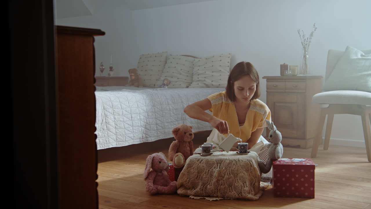 A girl playing with dolls in her room