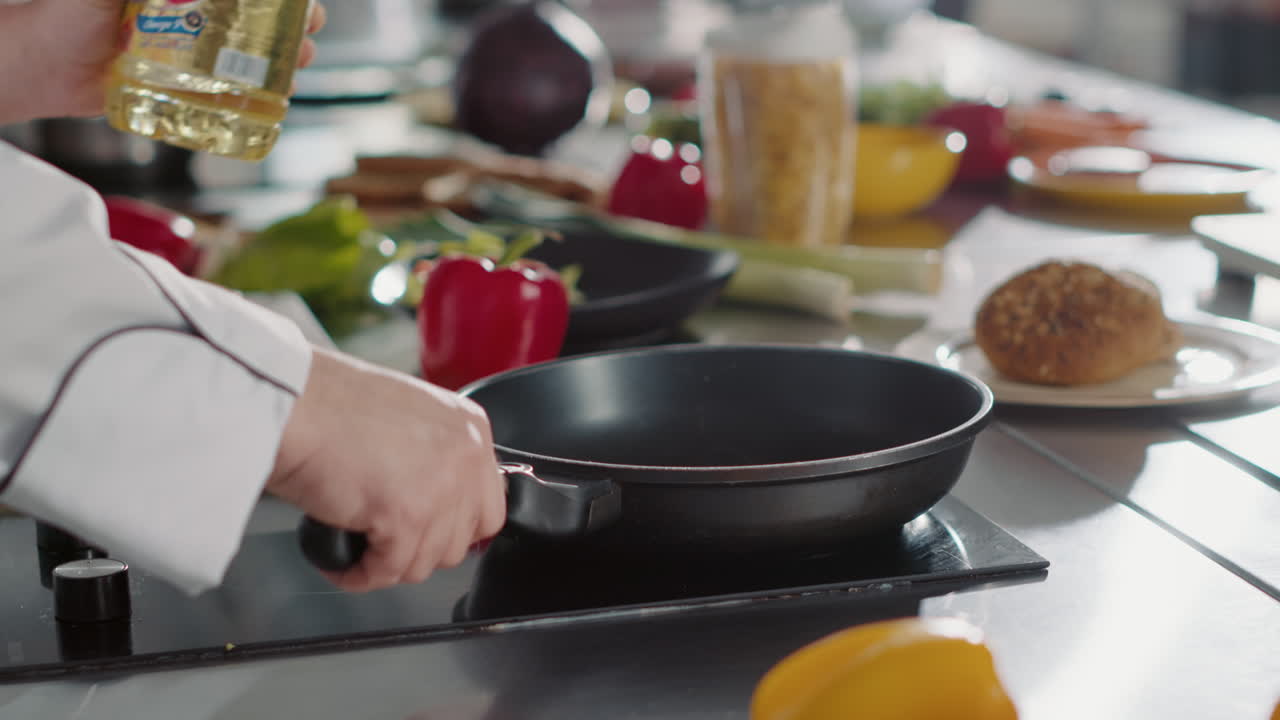 Gourmet chef pouring sunflower oil from bottle in frying pan