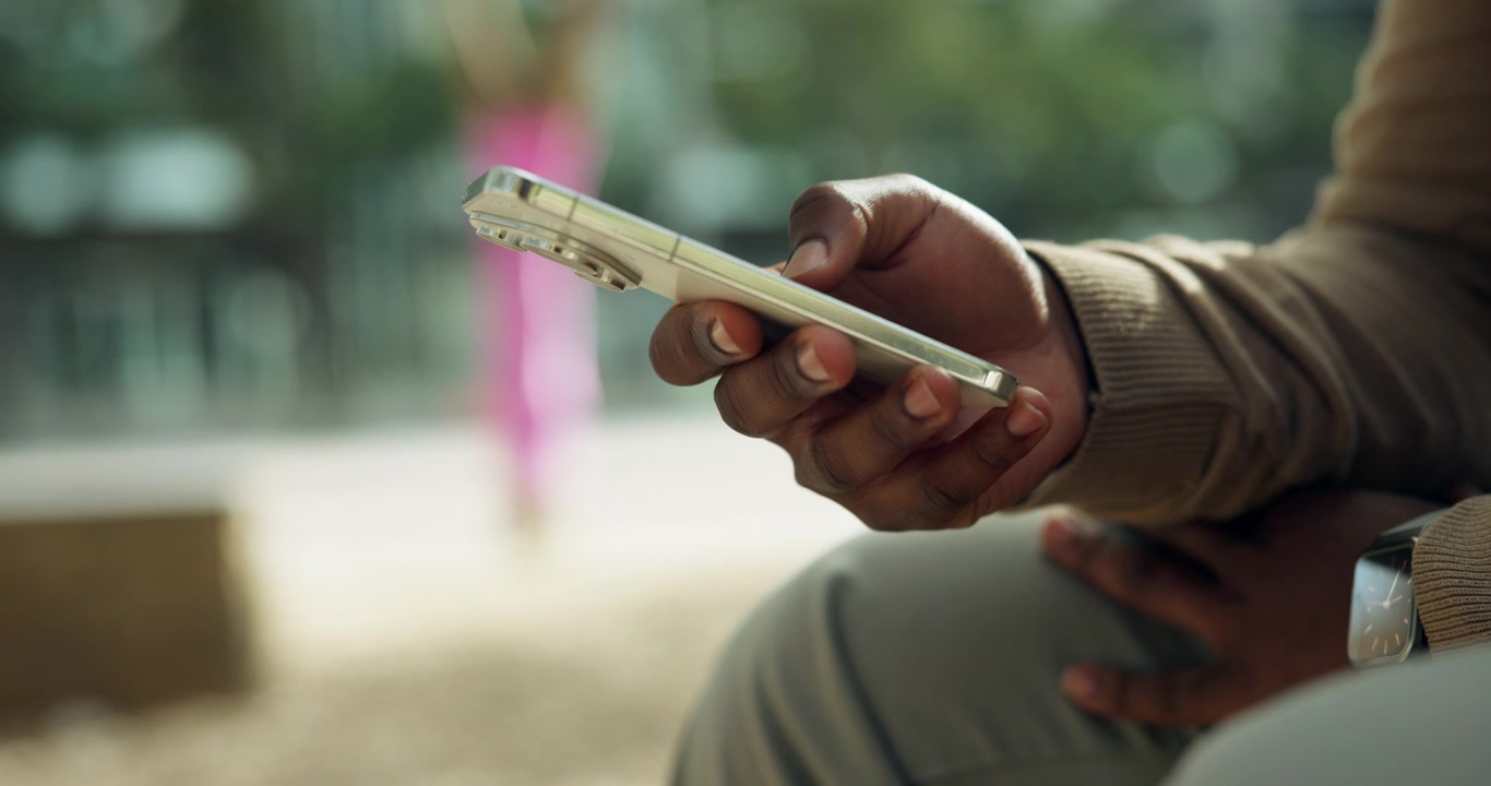 Person Using Smartphone Outdoors in Urban Setting