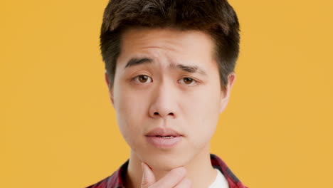 young asian man looking pensive