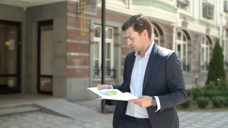 hombre en primer plano leyendo documentos en la calle. hombre yendo a trabajar en traje en la calle