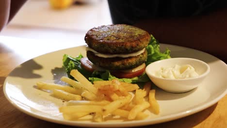 Comiendo-Hamburguesa-Vegana-Casera-Hecha-De-Garbanzos-Y-Combinada-Con-Mayonesa-Vegana