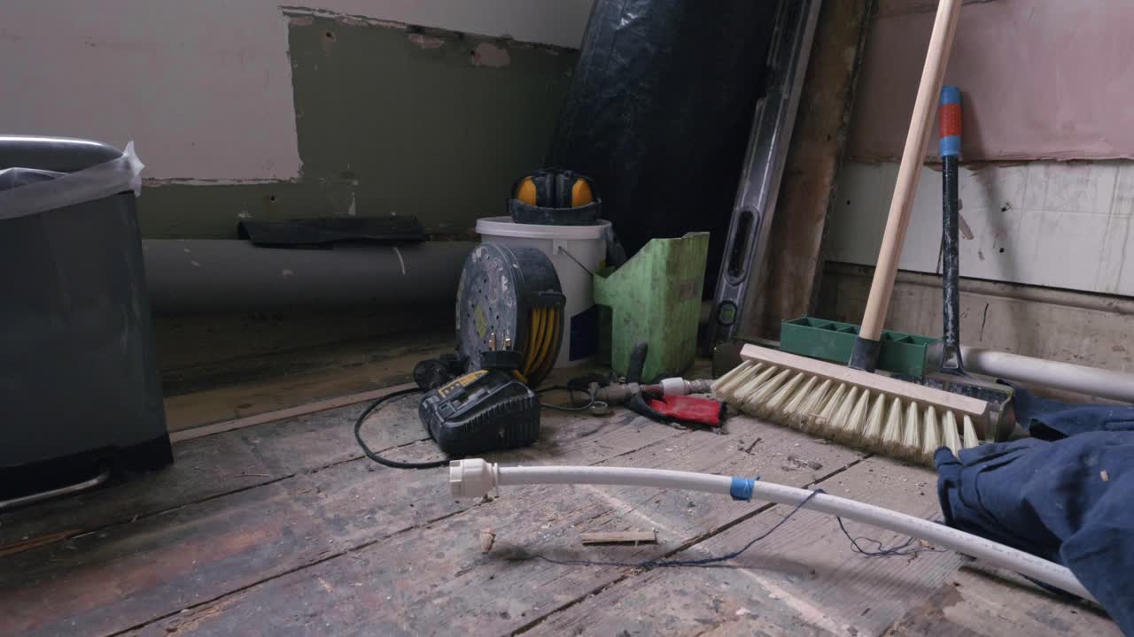 Bathroom renovation; crane up on tools in stripped back room during daytime