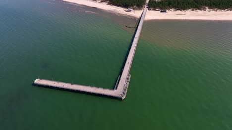 Panoramic-view-a-bridge-standing-on-the-beach-of-Palanga,-which-goes-to-the-Baltic-Sea