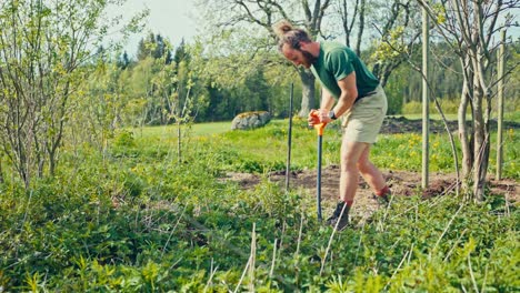 portrait of a caucasian man working on the garden with a shovel. static shot