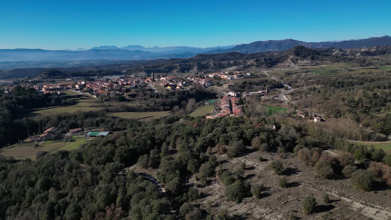 La regione di Tavertet a Barcellona con montagne e un villaggio in lontananza, vista aerea.
