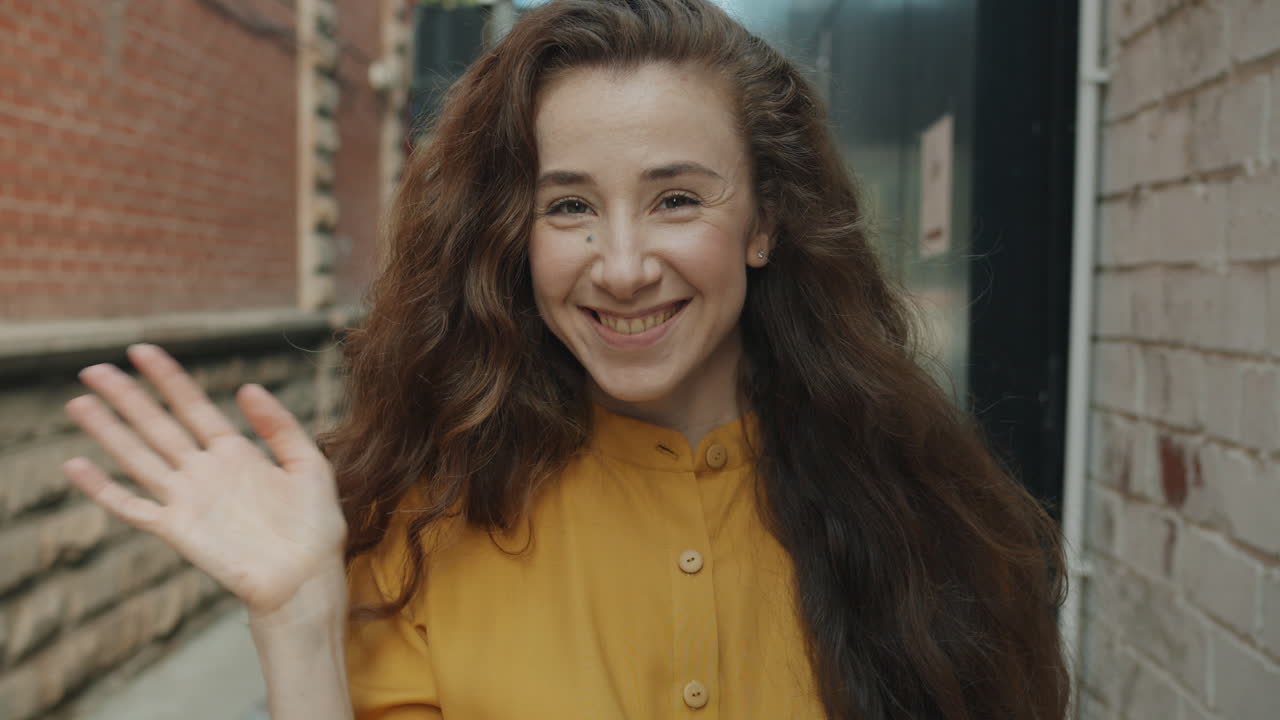 Woman waving in an urban alley