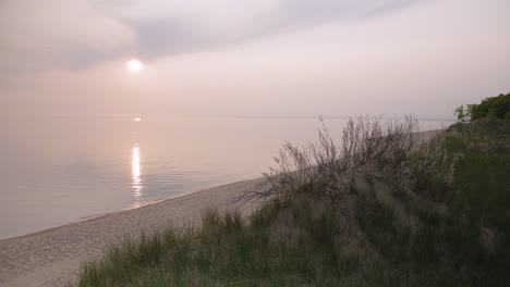 static shot of a beach sand dune near the shore of a large body of water